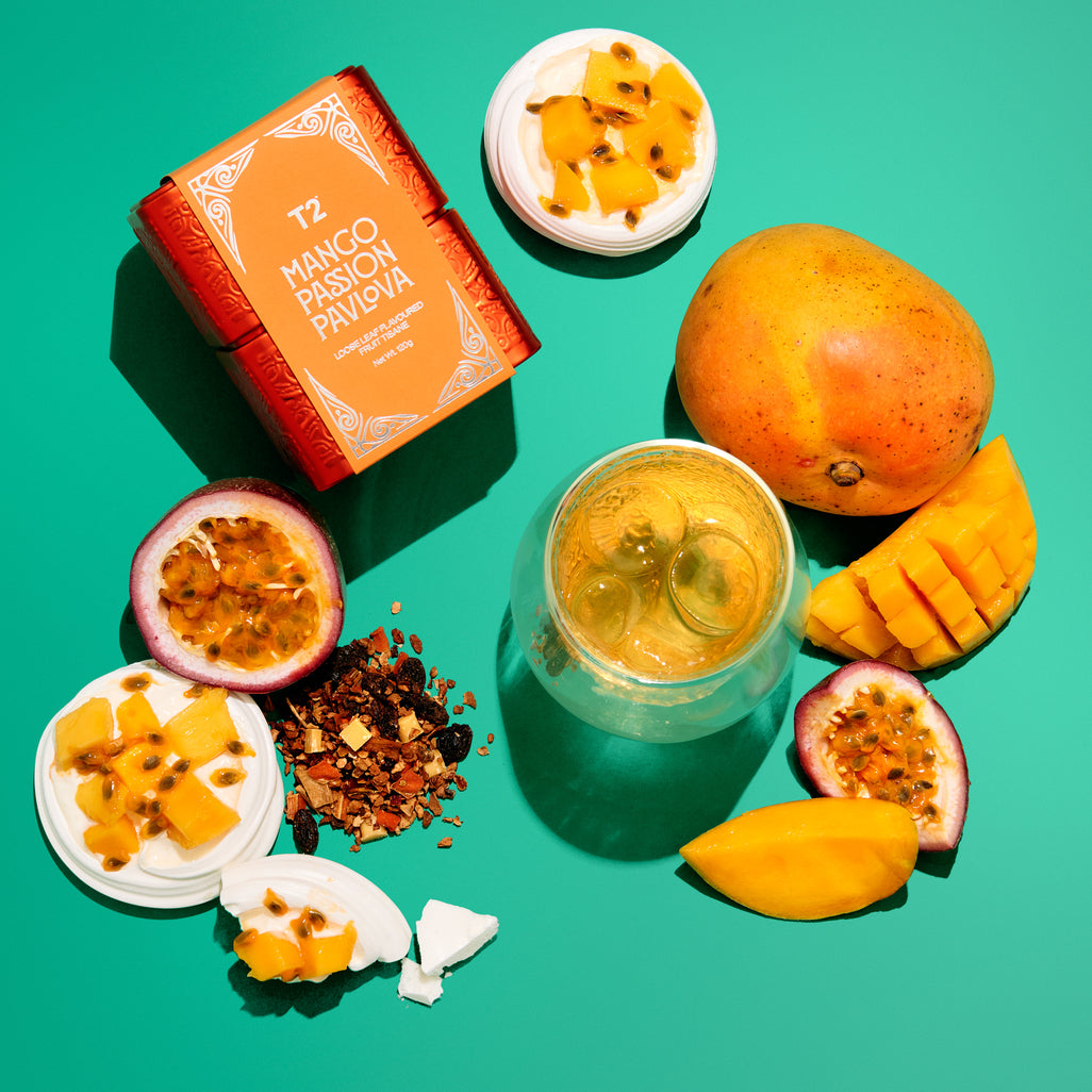 Mango and passion fruit ingredients with a T2 tea box on a green background