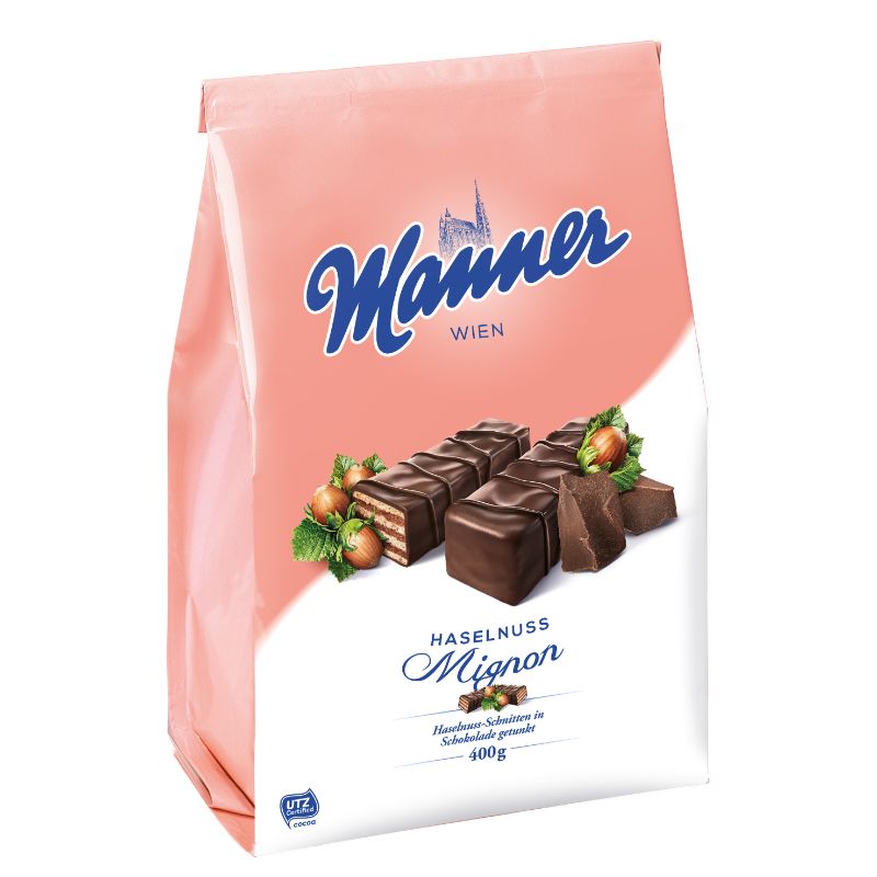 A 400g bag of Mannеr Wien Haselnuss Mignon chocolate wafer biscuits, featuring a pink and white package with blue branding and an illustration of chocolate-covered hazelnut mignon pieces.