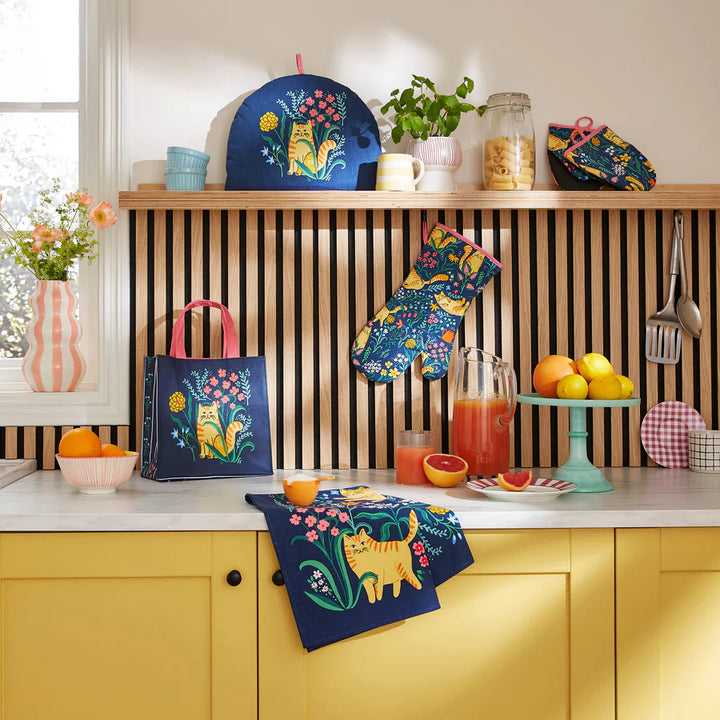 Colorful kitchen accessories with cat designs on a kitchen counter.
