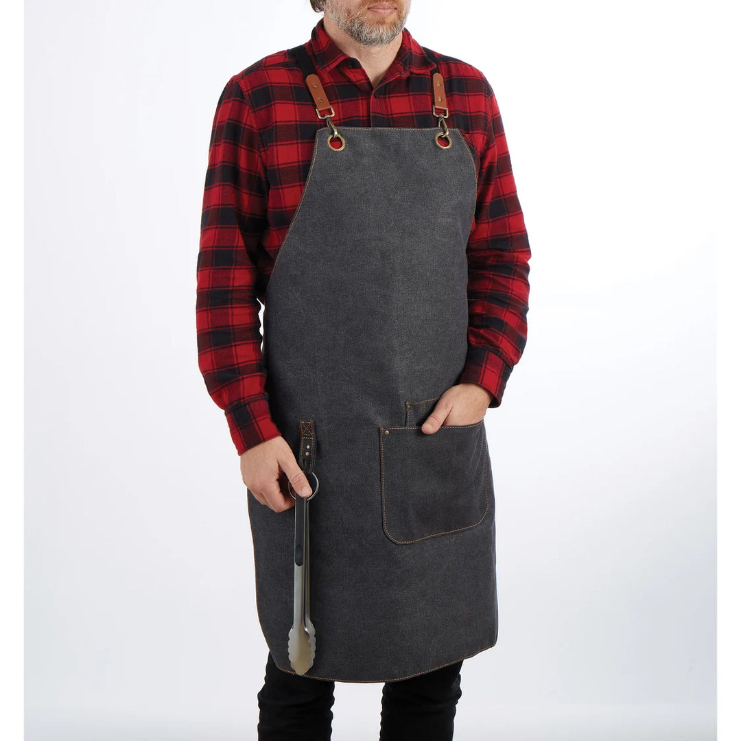 Person wearing a gray apron over a red and black plaid shirt on a white background