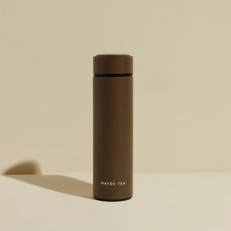 Brown thermos bottle with 'MAYDE TEA' branding on a beige background