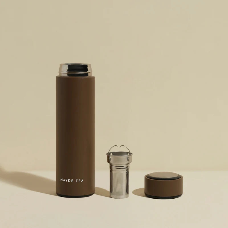Brown thermos bottle with detachable parts on a beige background