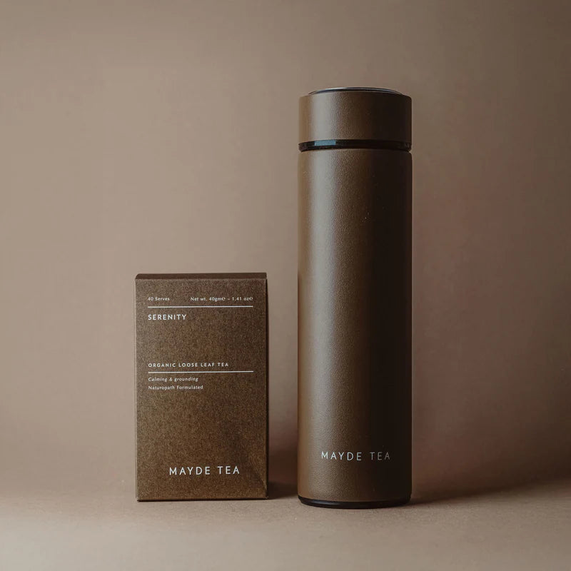 Brown thermos and tea box with 'Mayde Tea' branding on a beige background