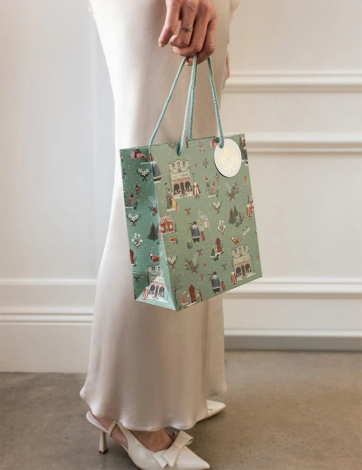 Person holding a patterned green bag with white background