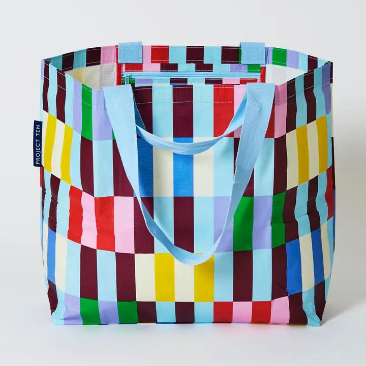 Colorful checkered tote bag with a blue handle on a white background