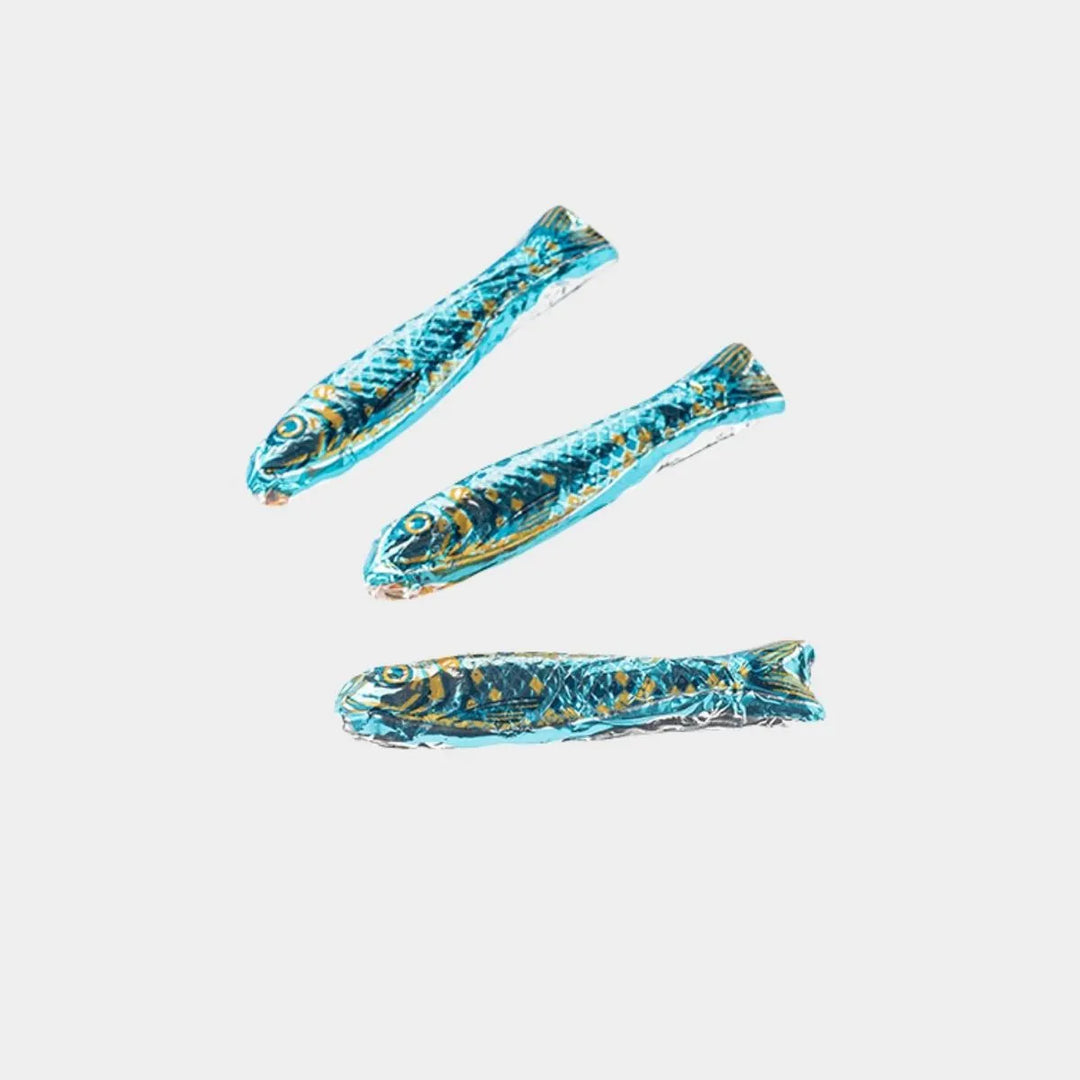 Three blue and gold fish-shaped objects on a light gray background