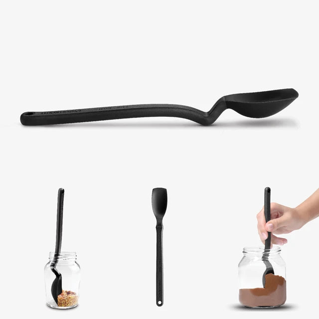Black spoon and spatula with a hand using the spoon to scoop from a jar on a white background