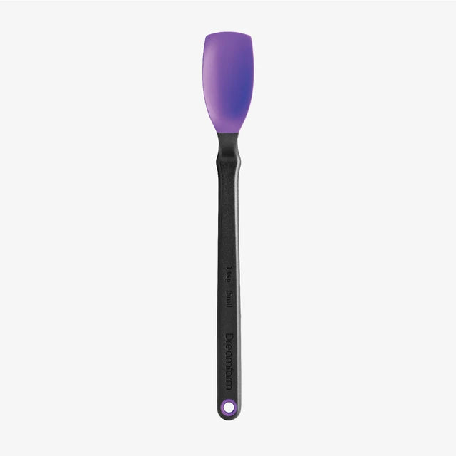 Silicone spatula with purple head and black handle on a white background