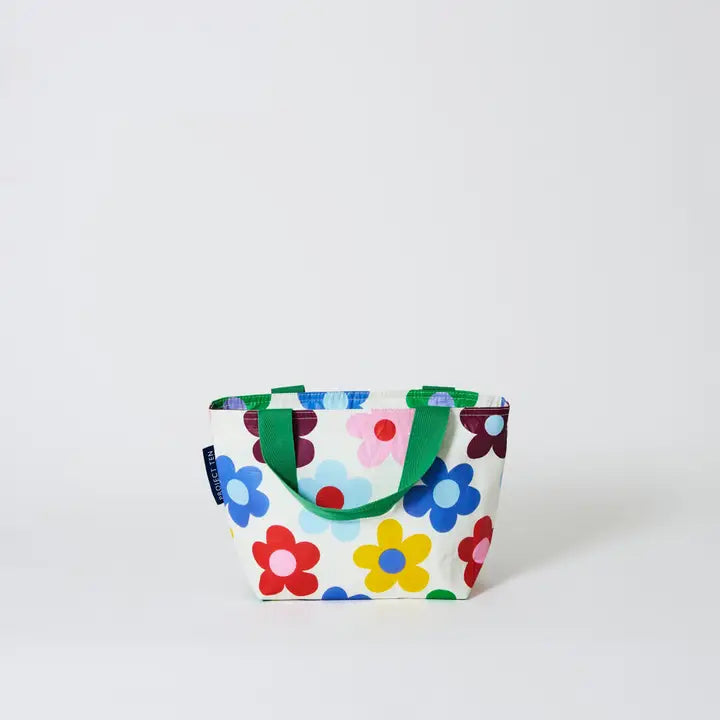 Colorful floral-patterned tote bag with green handles on a white background