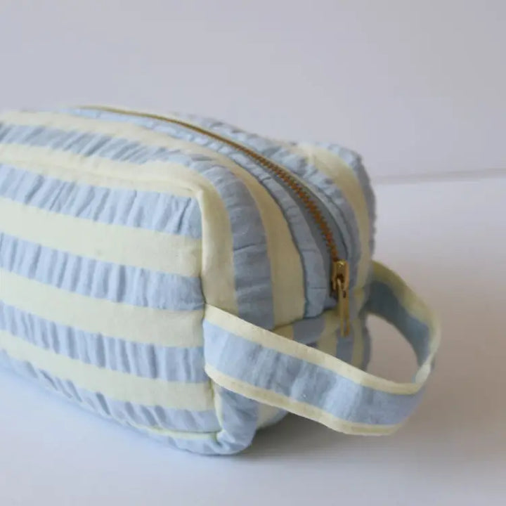 Blue and yellow striped pouch with a zipper on a white background