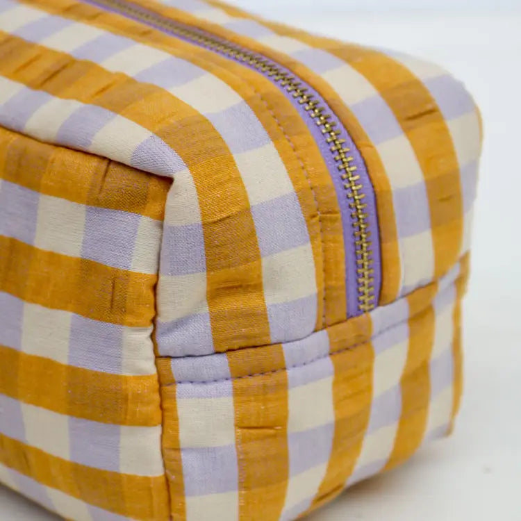 Yellow and purple checkered pouch with a zipper on a white background