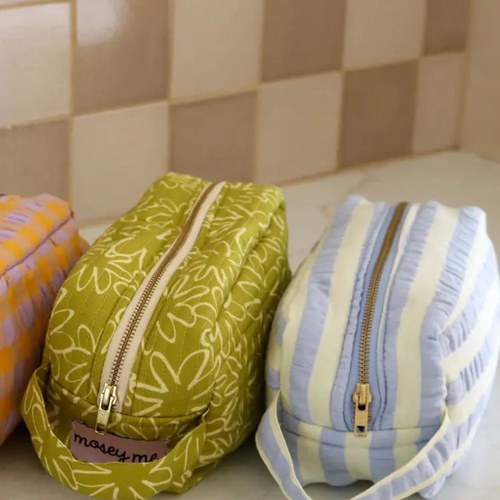 Three fabric bags with zippers on a tiled surface