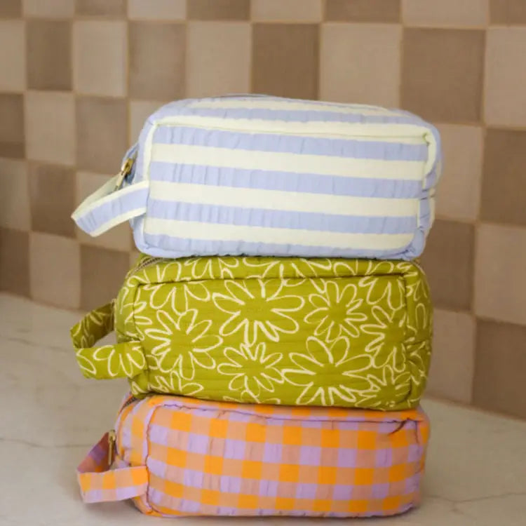 Stack of three fabric bags with different patterns on a tiled floor.