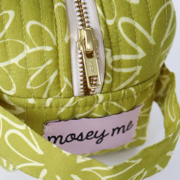 Green patterned bag with a gold zipper and &