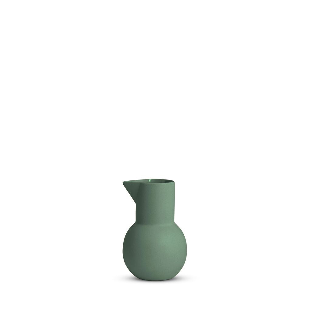 Green ceramic pitcher on a white background