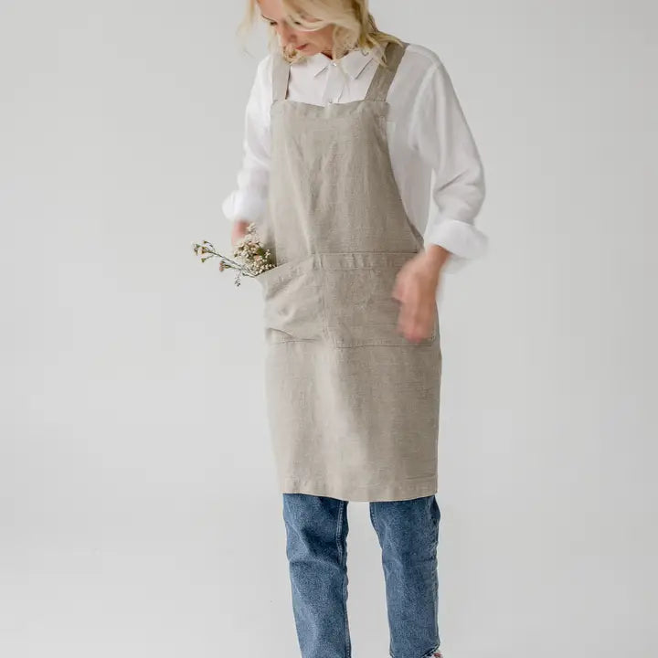 Person wearing a beige apron on a plain background