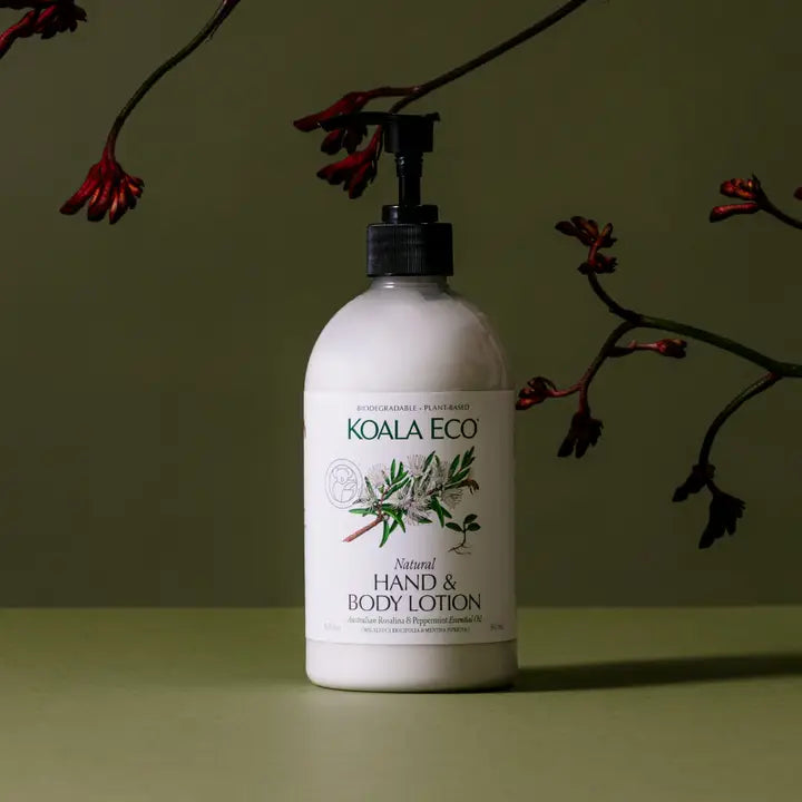 Koala Eco hand and body lotion bottle on a green background with branches.