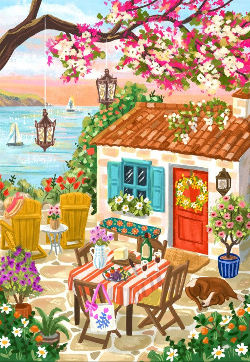 Cozy outdoor setting with a small house, table, chairs, and flowers by the sea.