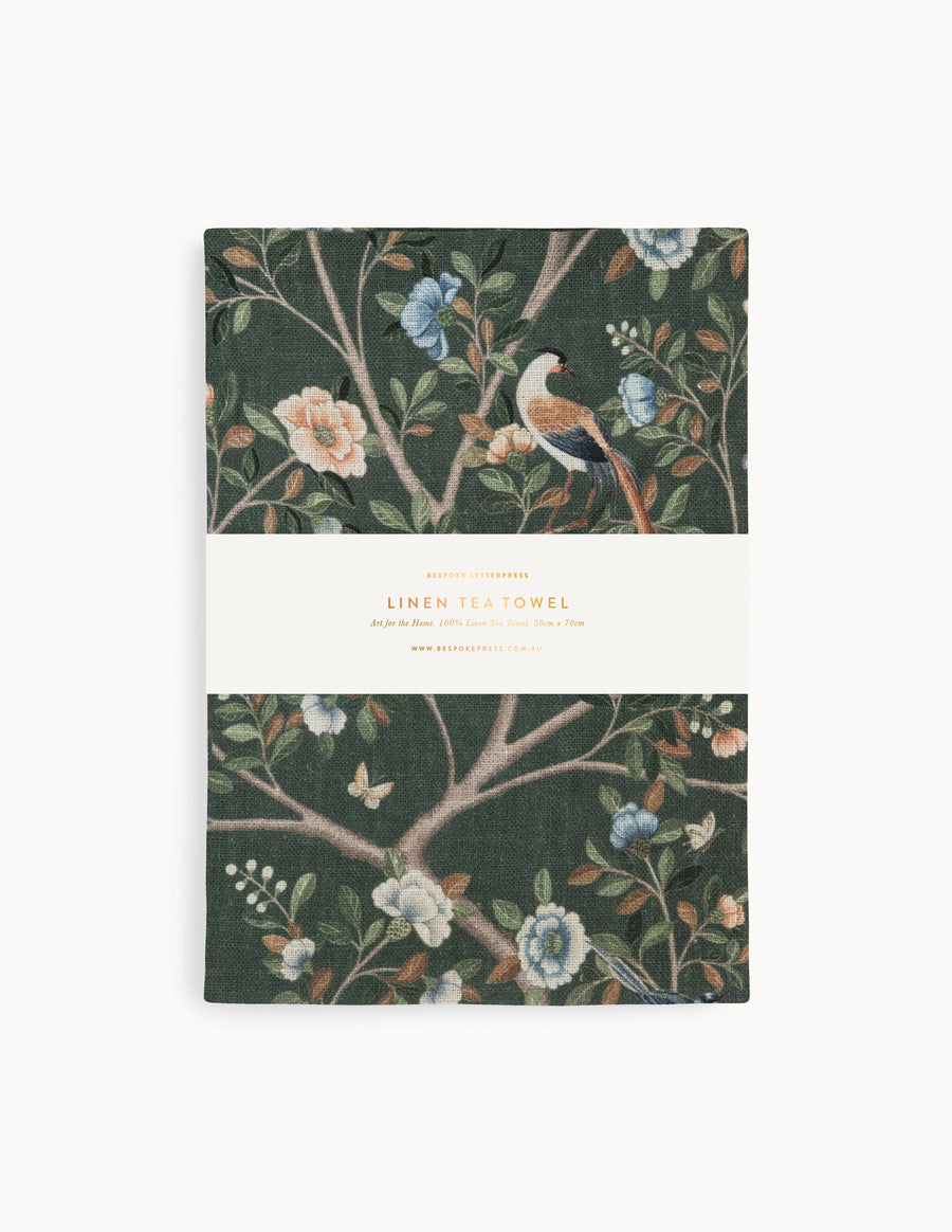 Packaged tea towel with floral and bird design on a white background