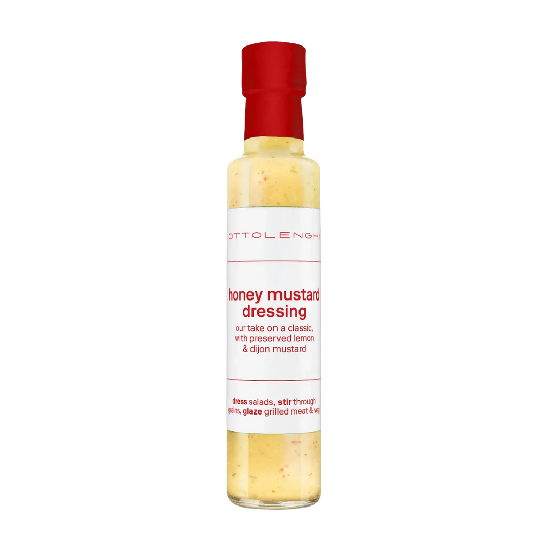 A bottle of Ottolenghi Honey Mustard Dressing with a red cap and white label, containing a pale yellow dressing, shown on a plain white background.