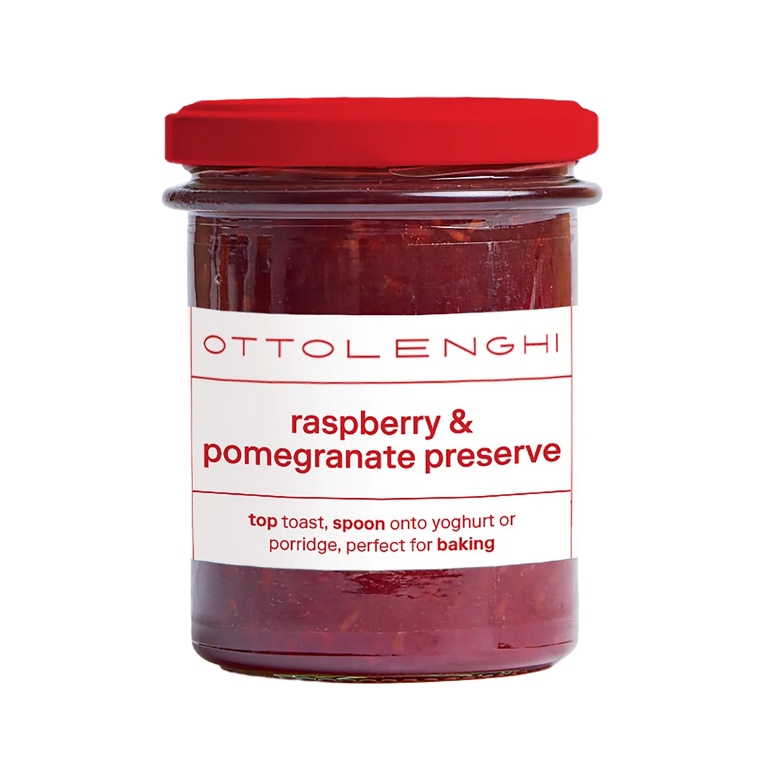 A jar of Ottolenghi Raspberry &amp; Pomegranate Preserve with a red lid and white label, shown on a plain white background.