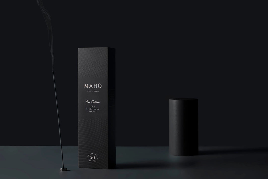 Black packaging with 'MAHO' branding with incense on a dark background