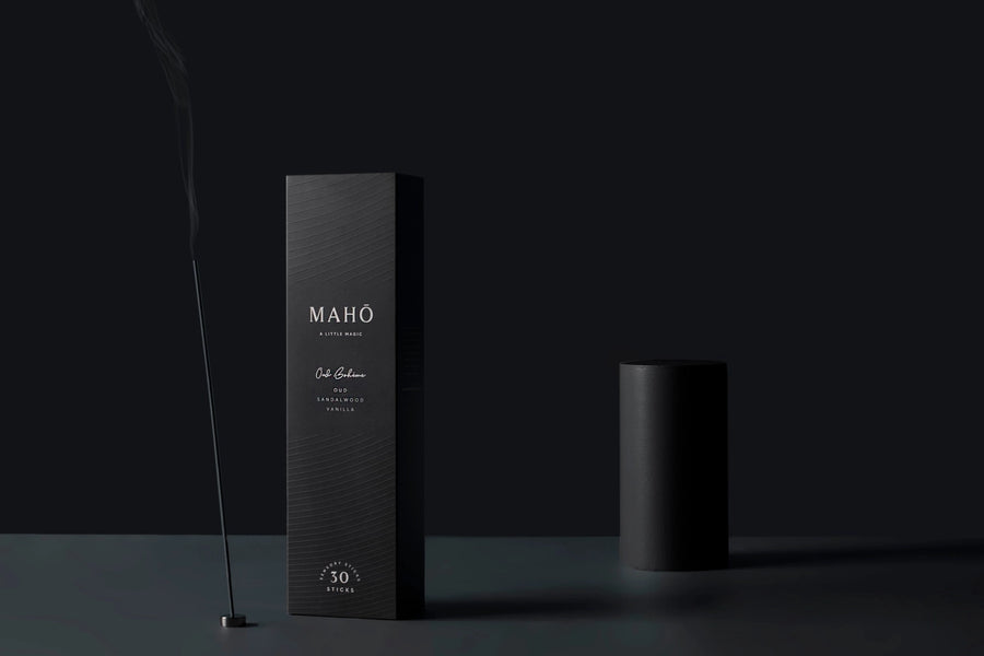 Black packaging with 'MAHO' branding with incense on a dark background