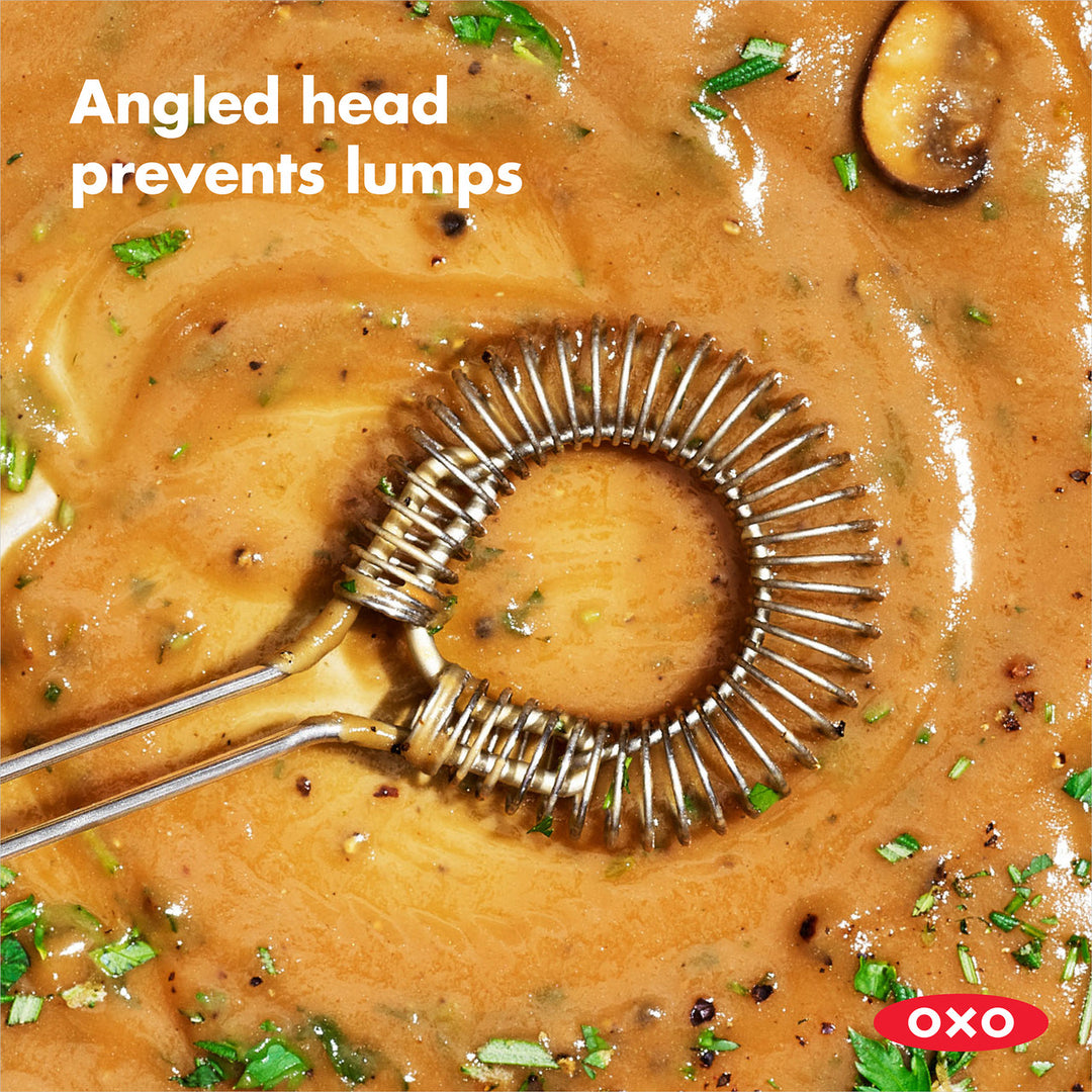 Metallic sauce and gravy whisk in a pot of soup with text &
