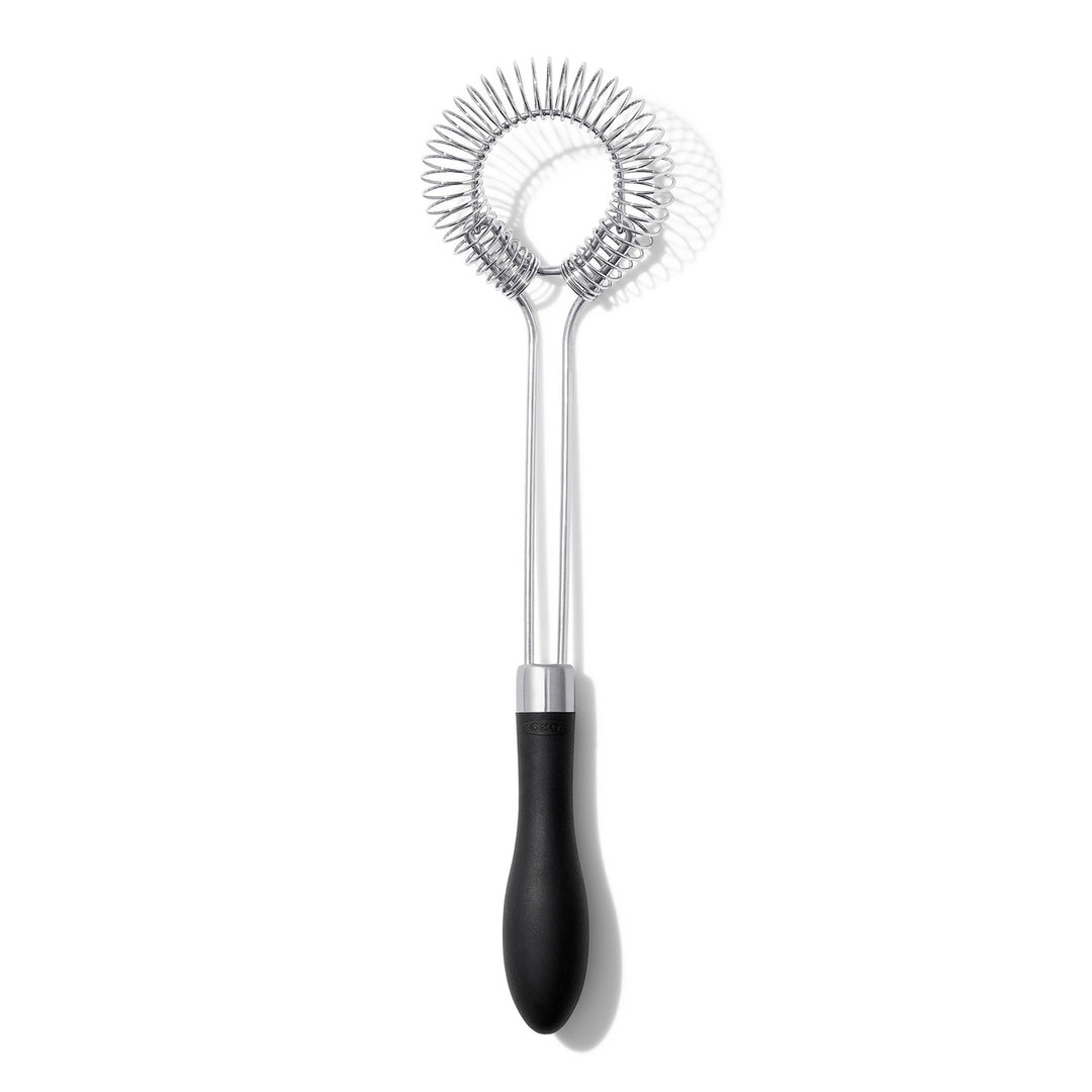 Metallic sauce and gravy whisk with black handle on a white background