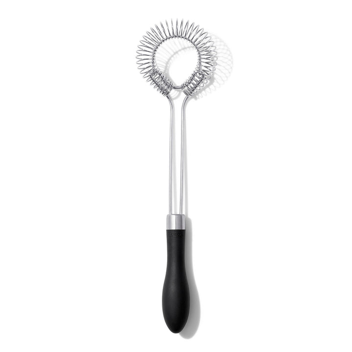 Metallic sauce and gravy whisk with black handle on a white background