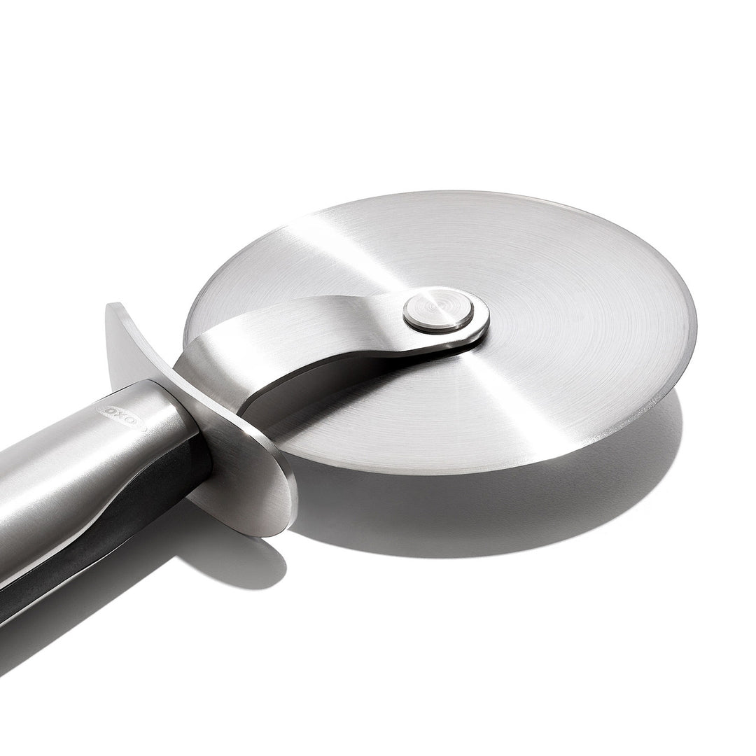 Stainless steel pizza cutter on a white background