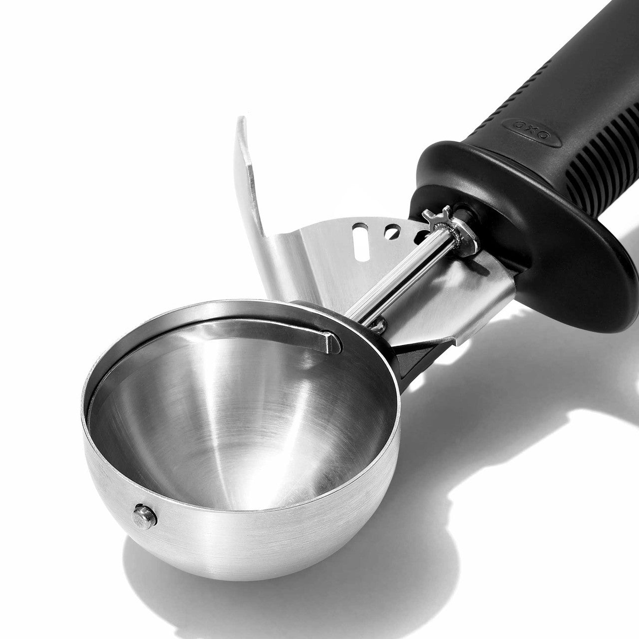 Metallic ice cream scoop with black handle on a white background