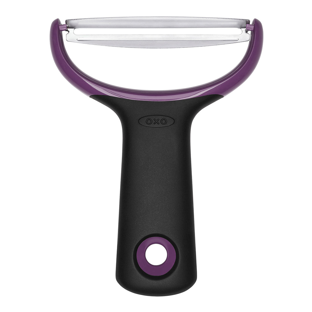 Oxo vegetable peeler with purple handle and blade on a white background
