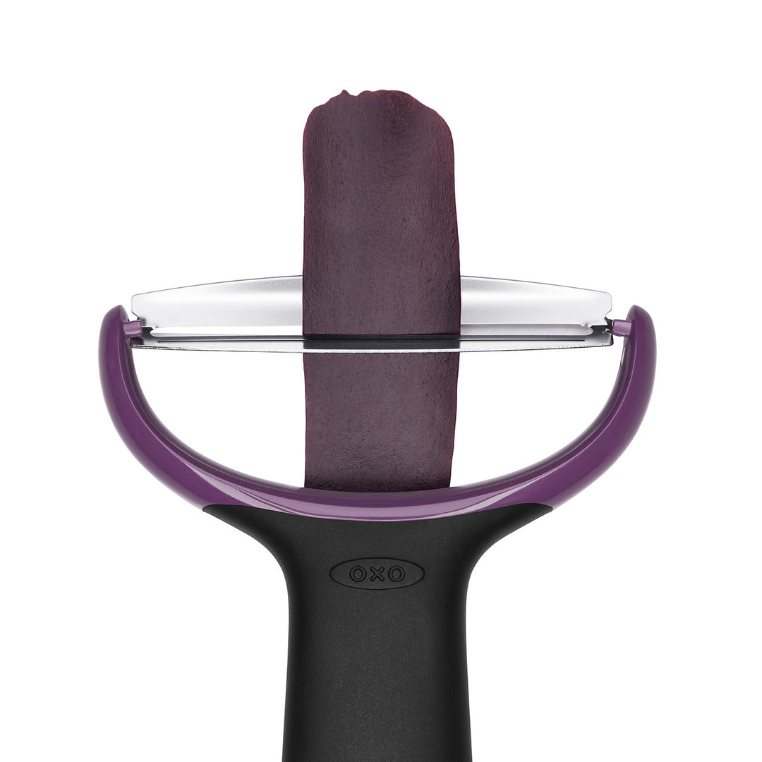 Purple and black vegetable peeler with a white background