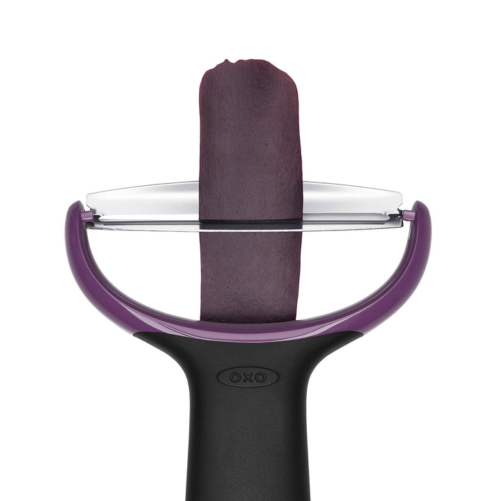 Purple and black vegetable peeler with a white background