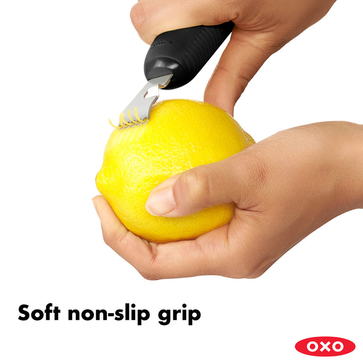 Hand using a citrus zester with a soft non-slip grip on a white background, featuring the OXO brand.