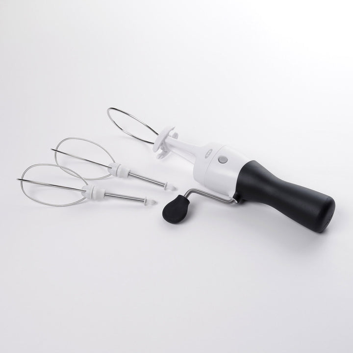 Handheld egg beater with attachments on a white background