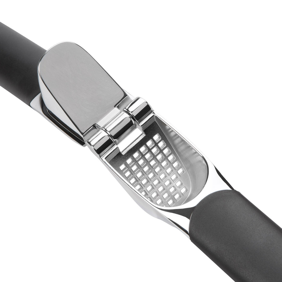 Garlic press with black handle and silver metal grid on a white background