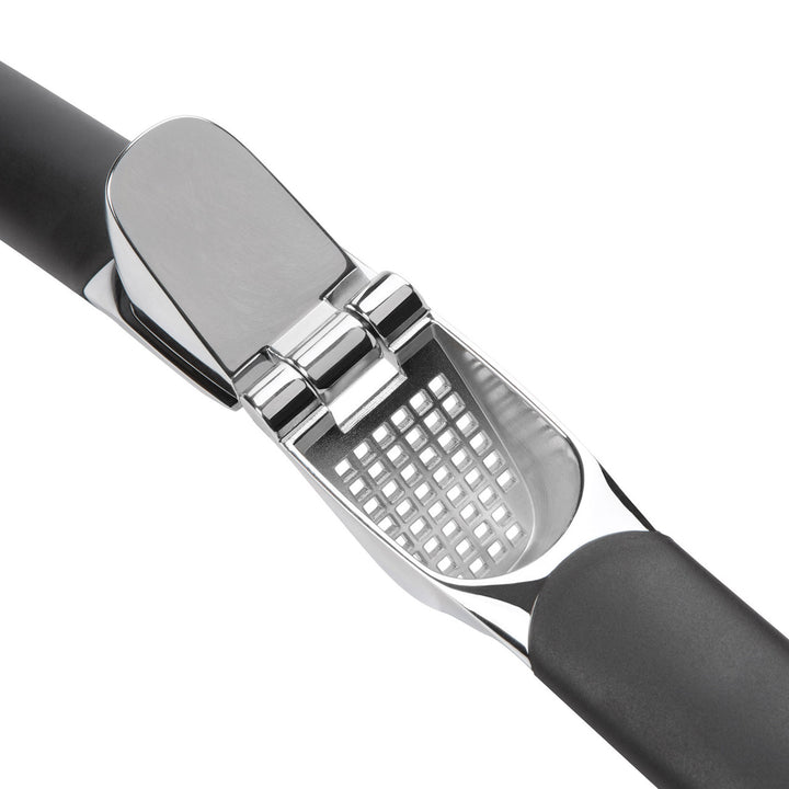 Garlic press with black handle and silver metal grid on a white background