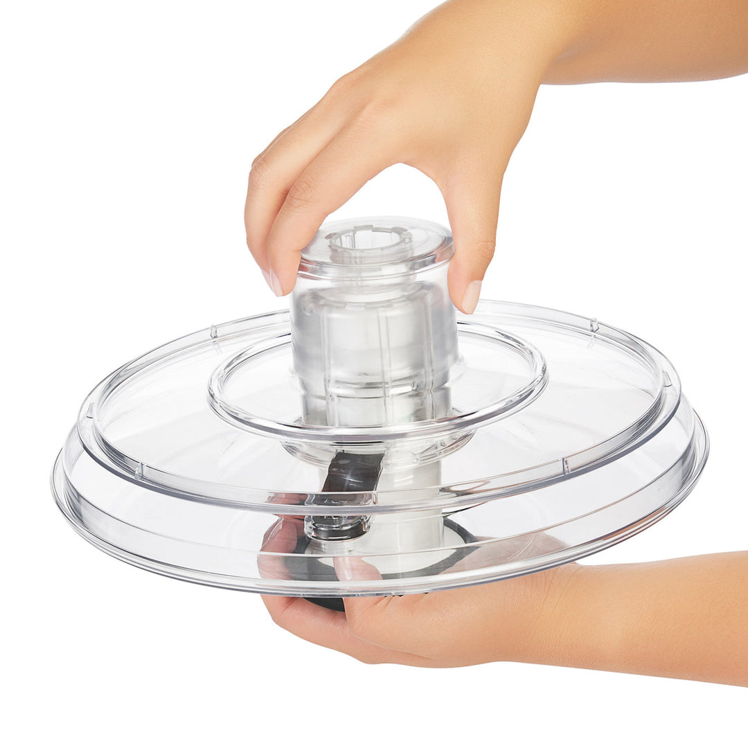 Clear plastic lid held by a hand on a white background