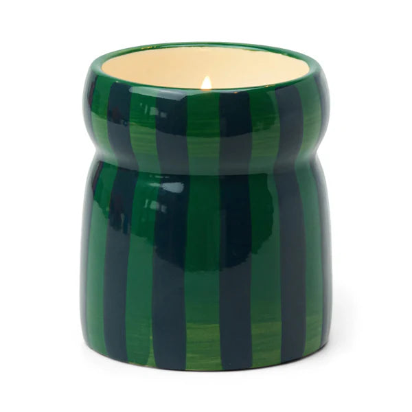 Green striped candle holder with a lit candle on a white background