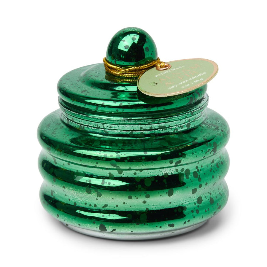 Green ceramic candle with a gold tag on a white background