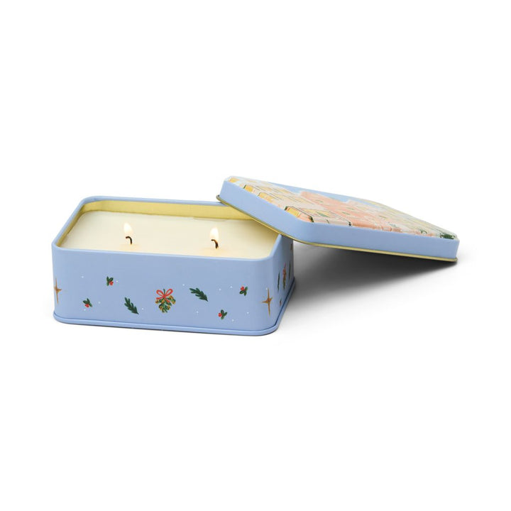 Candle in a decorative tin with Christmas designs on a white background