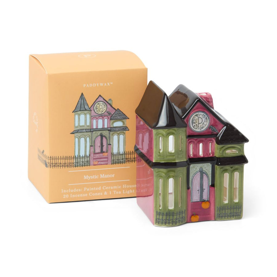 Ceramic house-shaped candle with decorative packaging on a white background