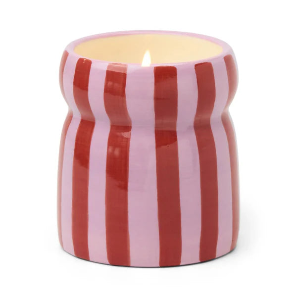 Candle in a red and white striped container on a white background