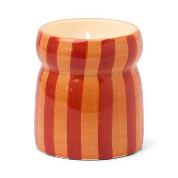 Candle in a striped container on a white background