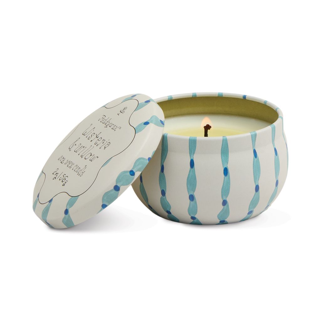 Candle in a decorative tin with wavy blue patterns on a white background