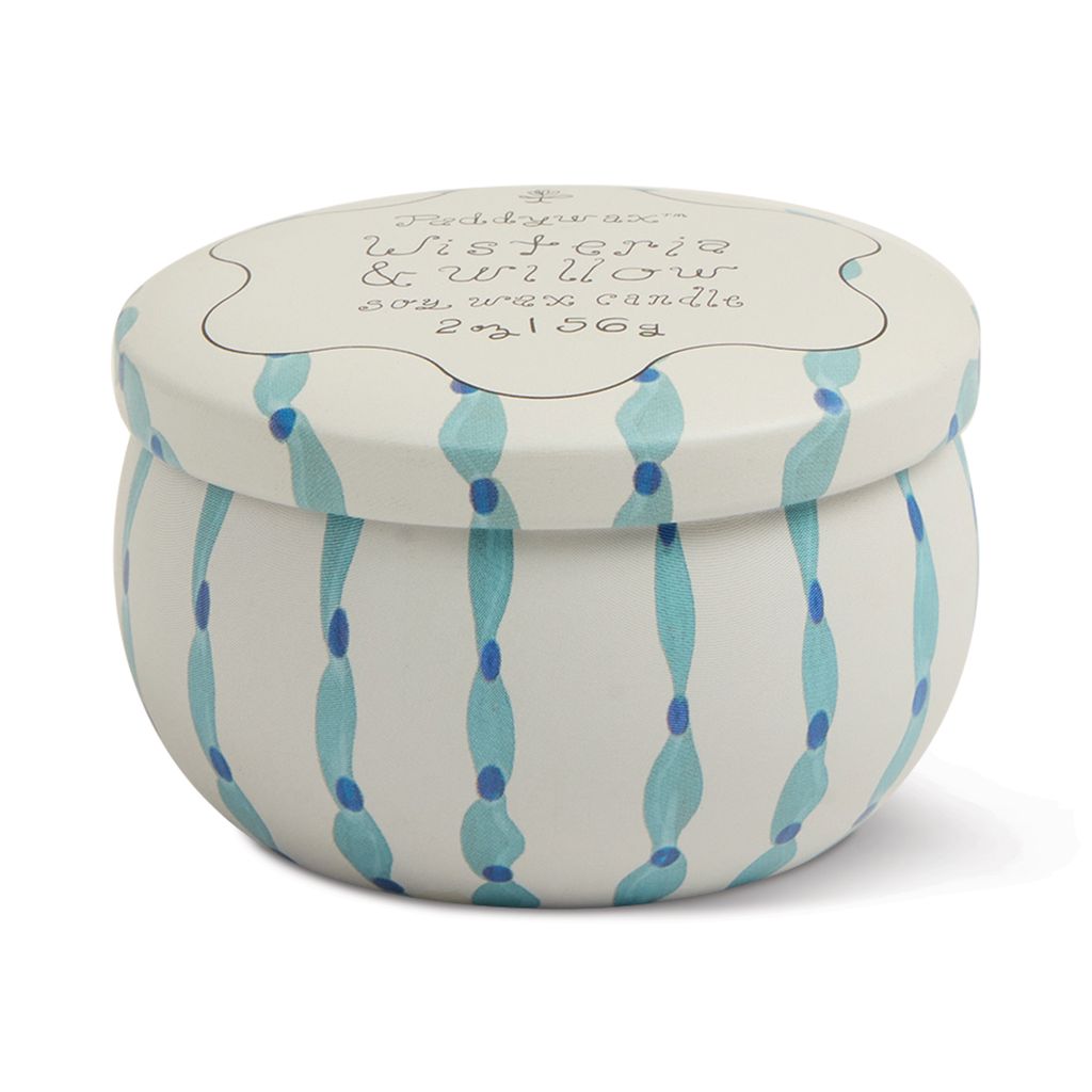 Small candle in a tin  with a lid featuring blue wave patterns on a white background