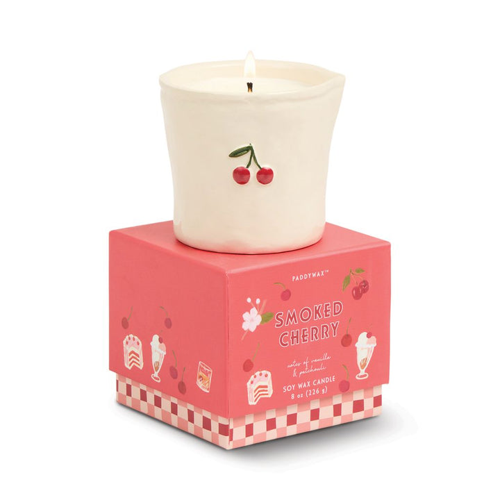 Candle with cherry design on a pink box labeled &