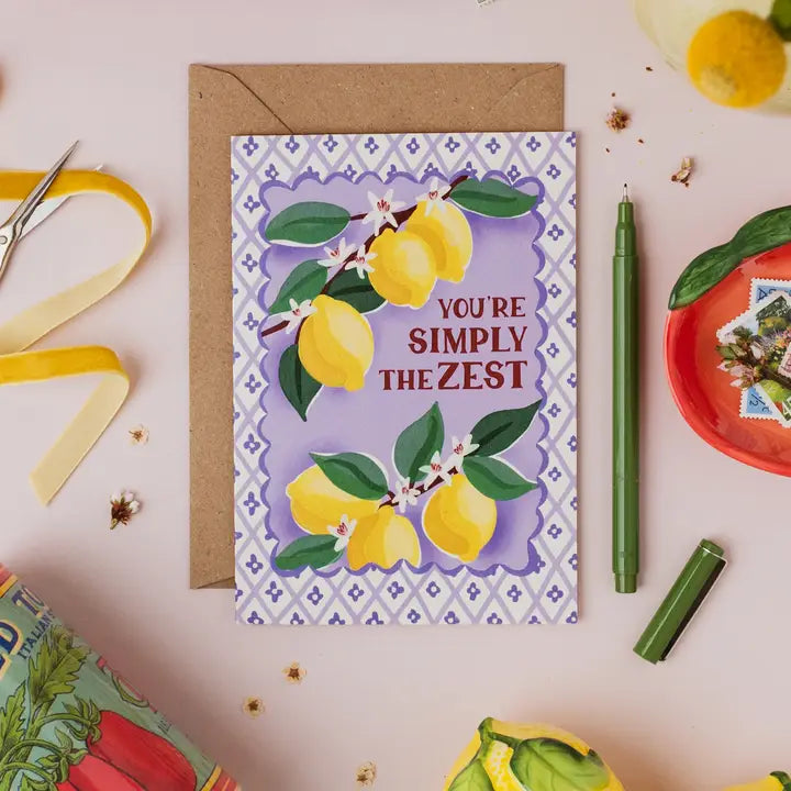 Greeting card with lemons and text 'You're Simply the Zest' on a decorative background.